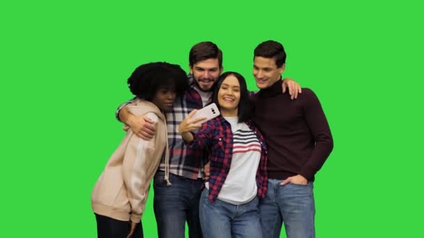 Studenten poseren voor een selfie, lachen, trekken grappige gezichten, tonen hun tong op een groen scherm, Chroma Key. — Stockvideo