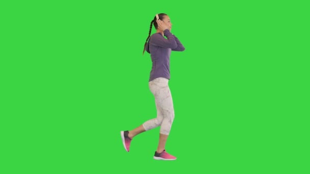 Menina bonita saudável jogging e ouve música com fones de ouvido em uma tela verde, Chroma Key. — Vídeo de Stock