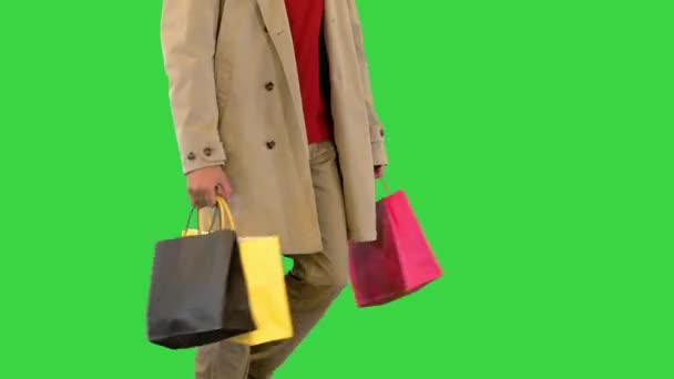 Borse della spesa nelle mani dell'uomo che cammina in un cappotto su uno schermo verde, Chroma Key. — Video Stock