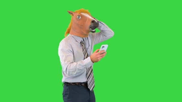 Uomo d'affari testa di cavallo essere scioccato mentre si cammina e utilizzando smartphone su uno schermo verde, Chroma Key. — Video Stock