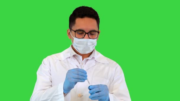 Legen trekker opp sprøyten med COVID-19-vaksine på et grønt skjerm, kromatøkkel. – stockvideo