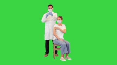 Doktor Corona virüsü aşısıyla genç bir kadını yeşil ekranda, Chroma Key 'de aşıladı..