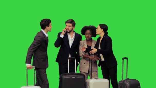 Podnikatelé na výlet, mladý muž se snaží zavolat taxi, zatímco ostatní se mu snaží pomoci vysvětlit jejich umístění na zelené obrazovce, Chroma Key. — Stock video