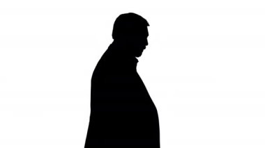 Siluet Olgun bir iş adamı saatine danışıyor.