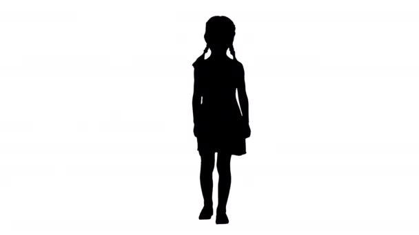Sylwetka Dziewczynka w sukience w kropki z ogonami świni spaceruje i uśmiecha się nieśmiało do kamery. — Wideo stockowe