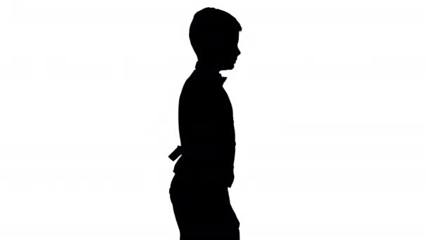 シルエット小さな男の子でウエストコートと蝶ネクタイをまっすぐ前を見て歩く. — ストック動画