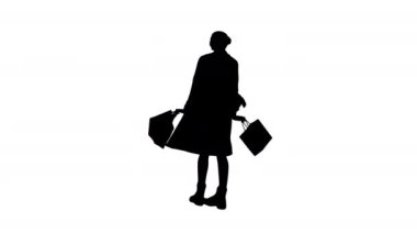 Siluet genç bayan alışveriş torbalarıyla dönen bir palto içinde.