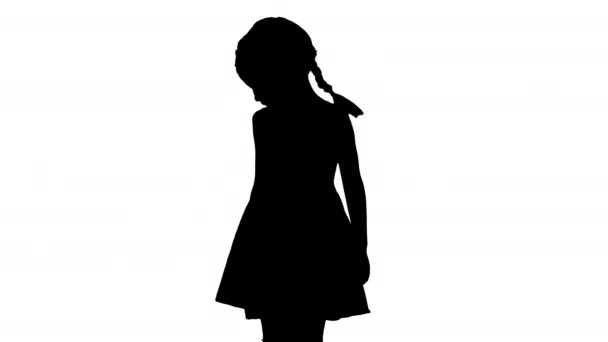 Silhouette Bambina in abito a pois guardando intorno e giù ai suoi piedi. — Video Stock