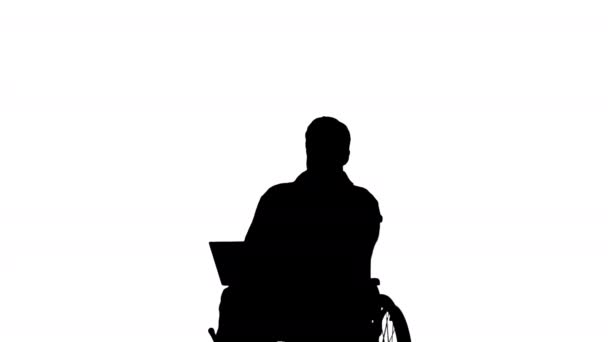 Silhouette Disabili vecchio in sedia a rotelle digitando sul computer portatile. — Video Stock