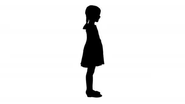 Silhouette Søt liten jente i prikkete kjole som snakker om noe til kameraet. – stockvideo