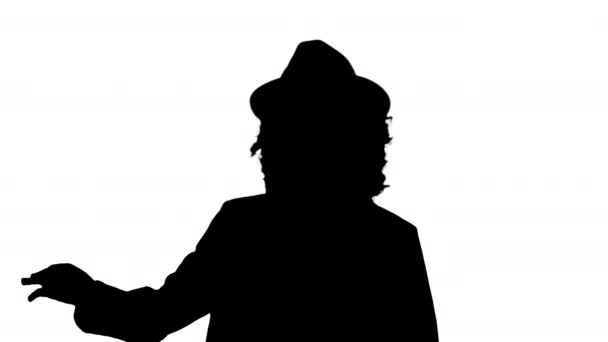 Silhouette Giovane donna afroamericana con un cappello inciampato mentre camminava e sorrideva. — Video Stock