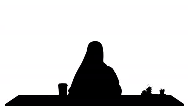 Silhouetteかわいいです若いです中東女性身に着けていますhijab使用ラップトップ. — ストック動画