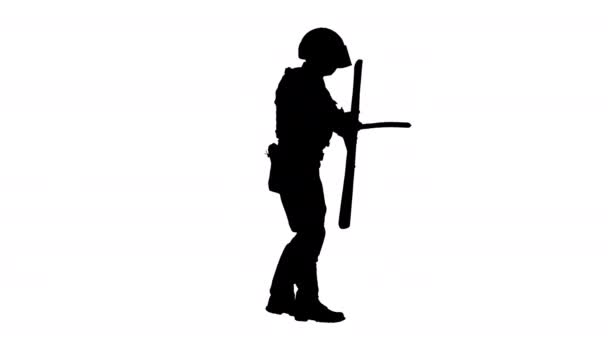 Silhouette Poliziotto antisommossa che colpisce lo scudo con il bastone mentre cammina. — Video Stock