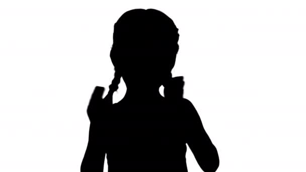 Silhouette Smiling little girl in polka dot dress clapping her hands vigorously looking at camera. — Stock Video