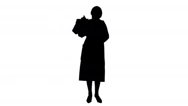 Silhouette Beautiful senior woman in trench coat holding shopping bags. — Stock Video