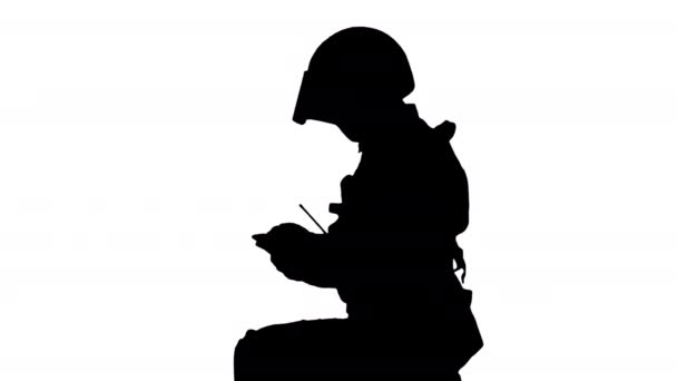 Silhouette Riot policeman sitting and using smartphone. — Stock Video