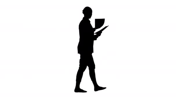 Silhouette Νεαρή επιχειρηματίας ψάχνει μέσα από έγγραφα, ενώ το περπάτημα. — Αρχείο Βίντεο