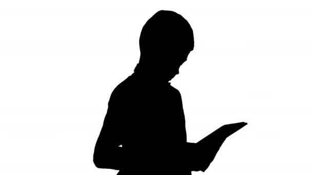 Silhouette Ragazzo concentrato utilizzando tablet digitale mentre in piedi. — Video Stock