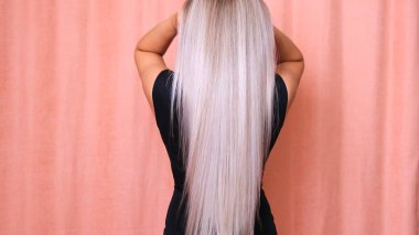 Genç bir kızın uzun sarı saçları, arkadan görünüşü. Saç bakımı konsepti.