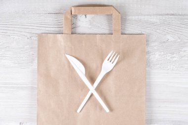 Plastik kullanmayı bırak. Plastik atık konsepti. Kapatın. Kahverengi ekolojik kağıt torba ve üzerinde plastik çatal ve bıçak vardı. Plastik ve ekoloji sorununun geri dönüşümü kavramı.