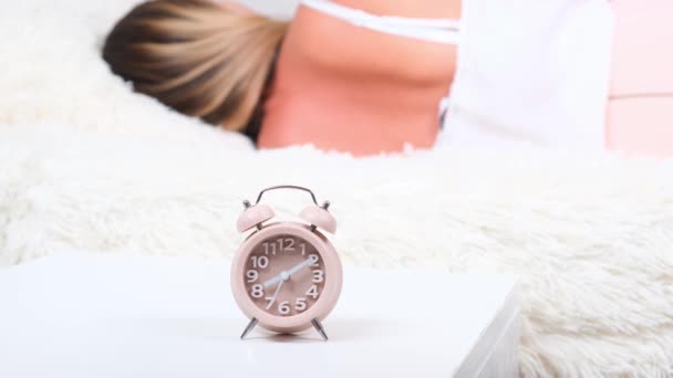 Женщина спит на кровати выключает будильник просыпается утром, выборочный фокус. — стоковое видео