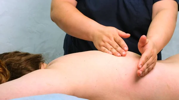 Therapeutic back massage. Massage therapist doing massage to a woman. Body care concept — Stock Photo, Image