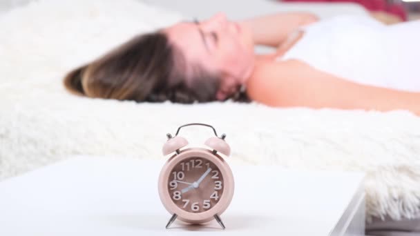 Femme dormir sur le lit éteint le réveil réveil le matin, mise au point sélective. — Video