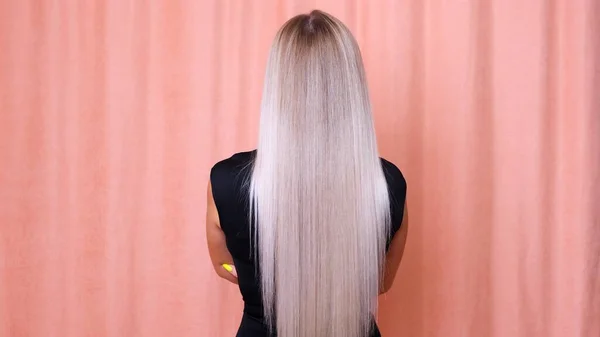 Longs cheveux blonds d'une jeune fille, vue de dos. Concept de soins capillaires. — Photo