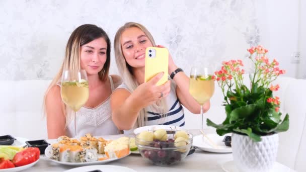 Два счастливых друга делятся онлайн-контентом с помощью смартфона дома, выборочный фокус — стоковое видео