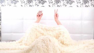 Dişi, elinde alarmlı bir saatle yatakta kalkar ve uyuduğunu fark eder. Zaman eksikliği, işe ya da okula geç kalmak.