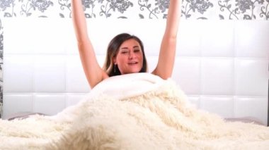 Komik kadın kahve eşliğinde yataktan kalkıyor, sabahları eğleniyor ve kahve içiyor. Yeni bir güne başlama kavramı, hafta sonları dinlenme, acele etmeye gerek yok, günaydın.