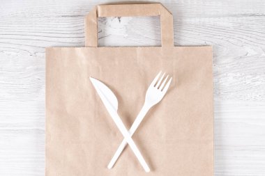 Plastik kullanmayı bırak. Plastik atık konsepti. Kapatın. Kahverengi ekolojik kağıt torba ve üzerinde plastik çatal ve bıçak vardı. Plastik ve ekoloji sorununun geri dönüşümü kavramı.