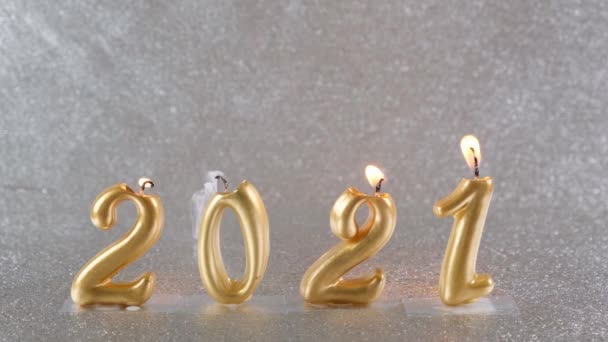 黄金の新年のろうそくを燃やす2021銀の背景に。現代的な概念は. — ストック動画