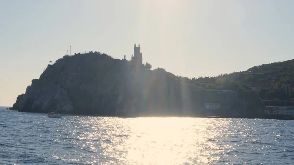 Vue sur la belle côte maritime avec le château Swallows Nest, Yalta, Crimée, prise d'un bateau de plaisance au coucher du soleil — Photo