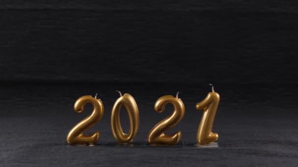 Bougies dorées éteintes Nouvel An 2021 sur fond noir. concept moderne. — Video