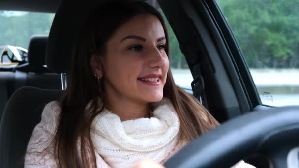 Fêmea alegre com uma expressão facial positiva alegre sentada no assento do motorista em um carro. Pessoas dirigindo, conceito de transporte. — Vídeo de Stock