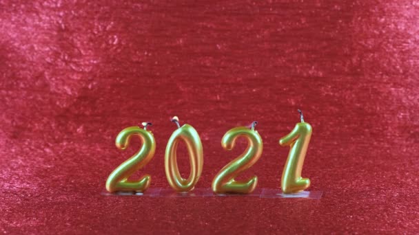 Bougies du Nouvel An en or éteintes 2021 sur fond rouge. concept moderne. — Video