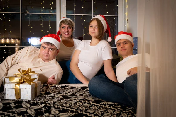 크리스마스 모자를 쓰고 선물을 교환하는 가족. — 스톡 사진