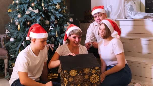 Famiglia in cappelli di Natale si scambia regali davanti all'albero di Natale. — Video Stock
