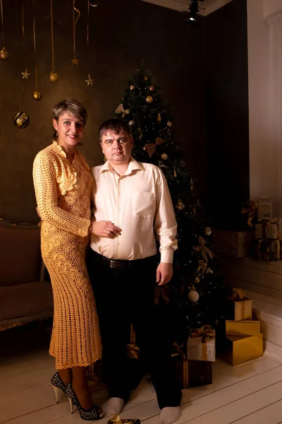 Birbirine aşık bir çiftin portresi, Noel ağacının yanında sarılıyorlar. — Stok fotoğraf