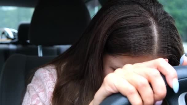 Smutná a unavená žena se opřela hlavou o volant, plakala, když seděla v autě. — Stock video