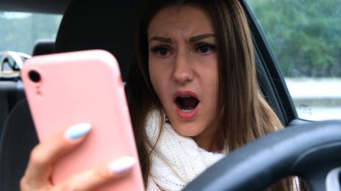 Araba sürerken akıllı telefon kullanan bir kadın şaşırdı. Kötü haber kavramı.