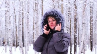 Kadın kış günü cep telefonu kullanıyor, yakın plan.