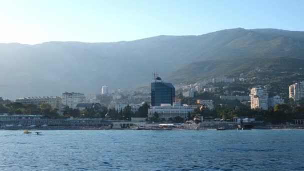 Vista da bela costa marítima de Yalta, Crimeia, tirada de um barco de recreio ao pôr do sol, excursão pelo mar ao longo da costa da Crimeia — Vídeo de Stock