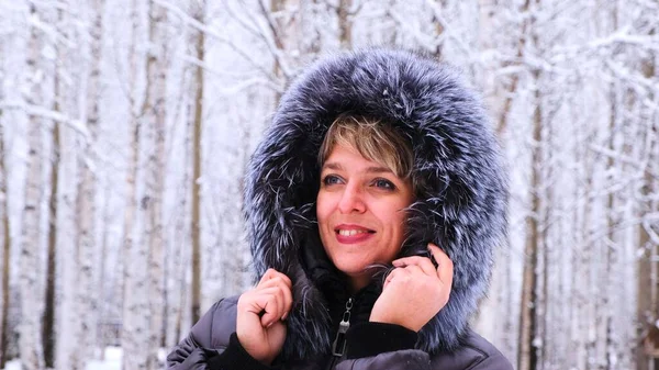 Zimní portrét mladé krásné brunetky v zimní bundě s kožešinou. Sněhová zimní krása koncept — Stock fotografie