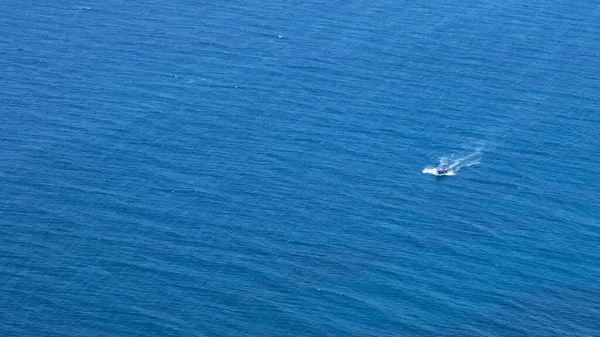 Piccola barca si muove su un bellissimo mare blu — Foto Stock