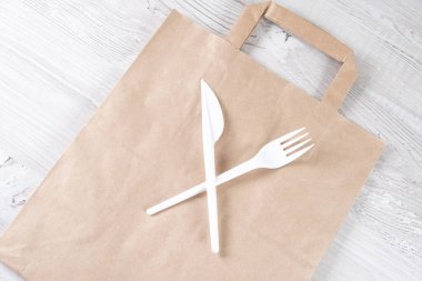 Plastik kullanmayı bırak. Plastik atık konsepti. Kapatın. Kahverengi ekolojik kağıt torba ve üzerinde plastik çatal ve bıçak vardı. Plastik ve ekoloji sorununun geri dönüşümü kavramı.