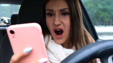 Araba sürerken akıllı telefon kullanan bir kadın şaşırdı. Kötü haber kavramı.