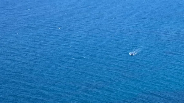 Piccola barca si muove su un bellissimo mare blu — Foto Stock