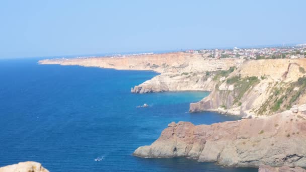 Spiaggia balneare sul capo Fiolent a Balaklava, Crimea. Vista dalla cima della roccia. mare azzurro, giornata di sole cielo limpido sfondo. Il concetto di luogo perfetto per i viaggi estivi e il riposo. — Video Stock